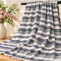 Tissu coton rayé blanc gris et noir présenté sur barre noire avec fleurs
