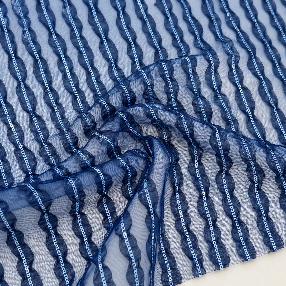 Mise en scène illustrative du détail de la dentelle bleue à rayures ondulées en polyester