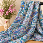 Mise en scène illustrative du tissu cachemire drapé sur barre noire avec vase de fleurs