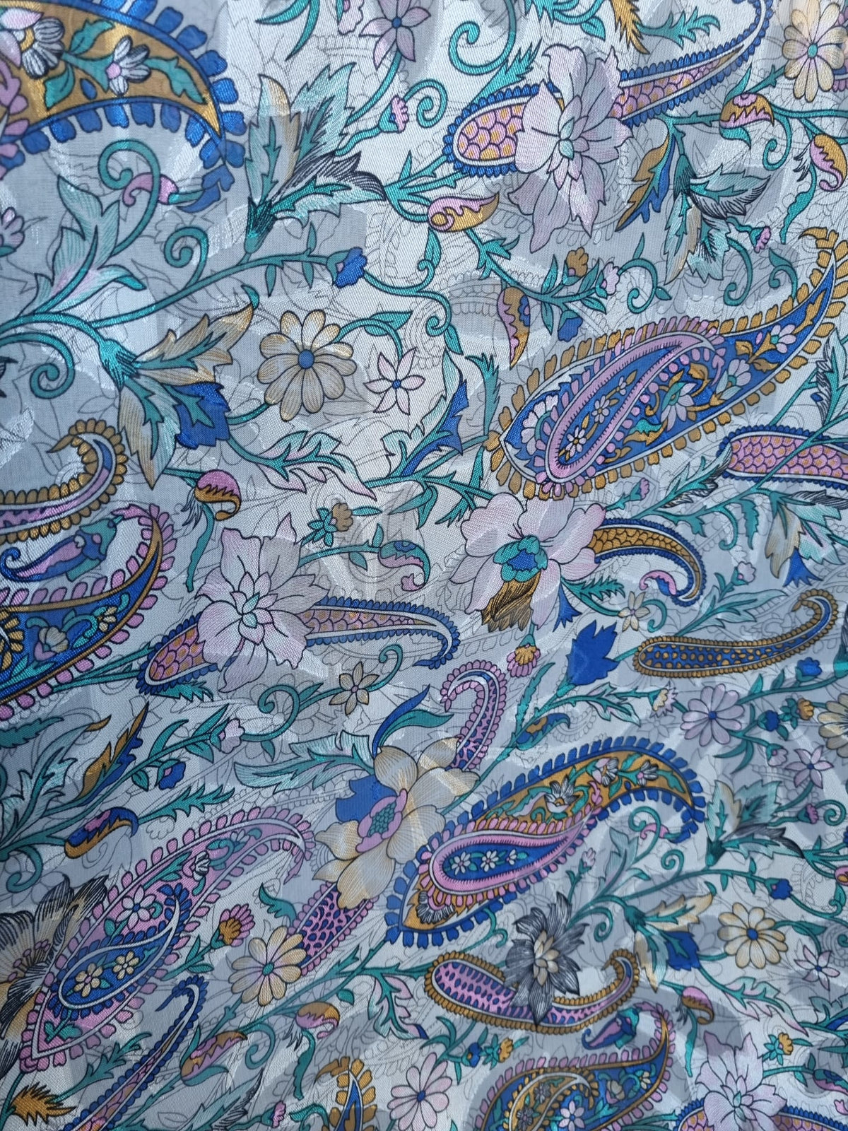 Photo réelle du tissu fleuri et motif cachemire multicolore sur fond gris clair