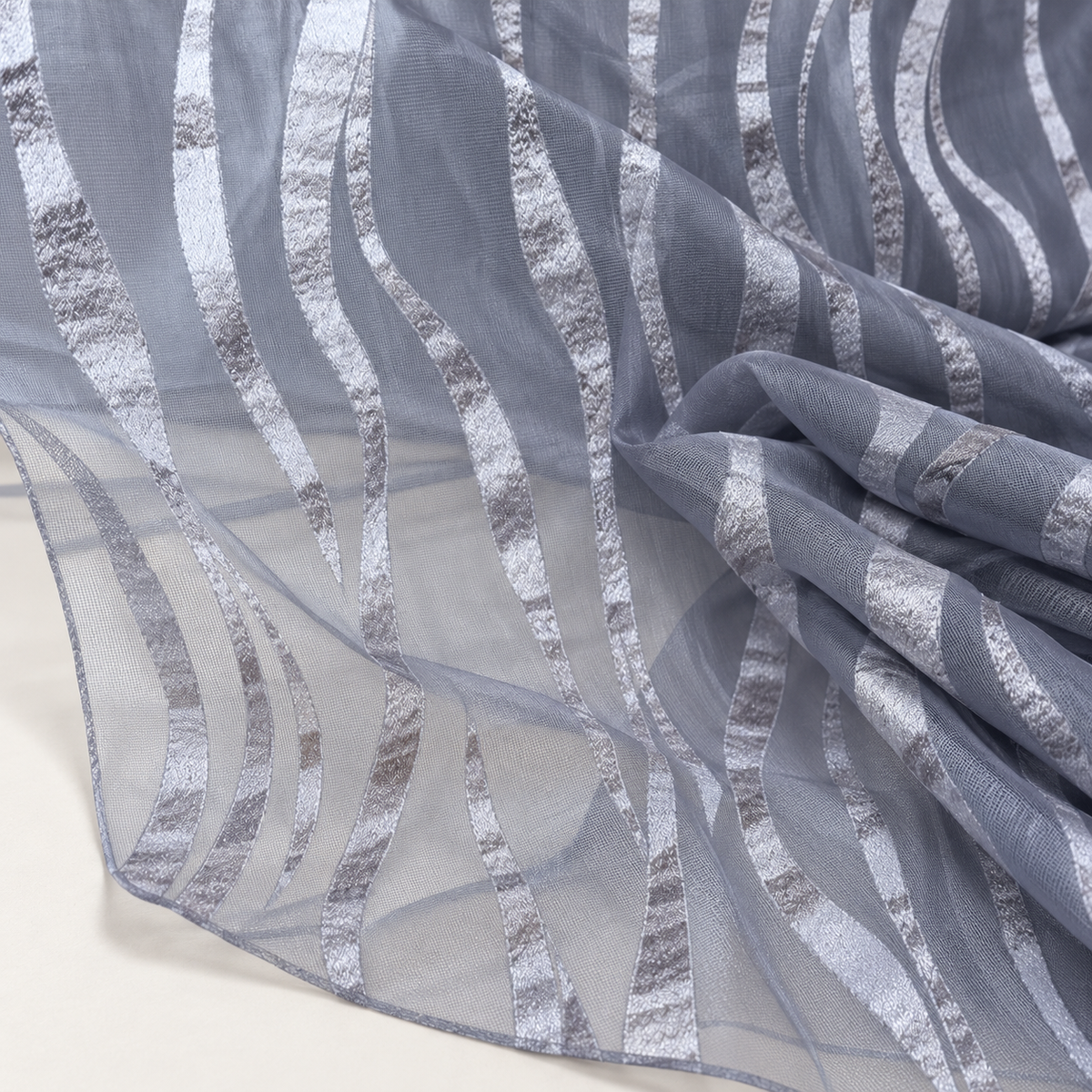 Mise en scène illustrative du détail du tissu transparent gris polyester à motifs ondulés